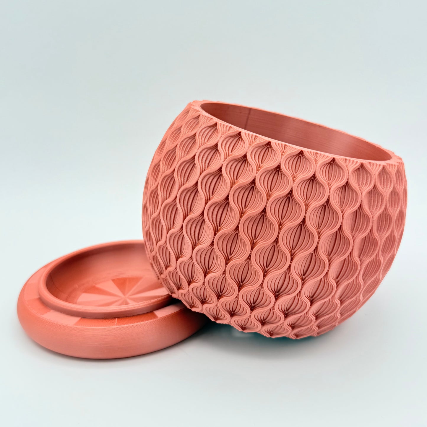 This 3D printed Lotus Planter with drainage tray has an intricate, flower-like pattern. Shown in rose gold.