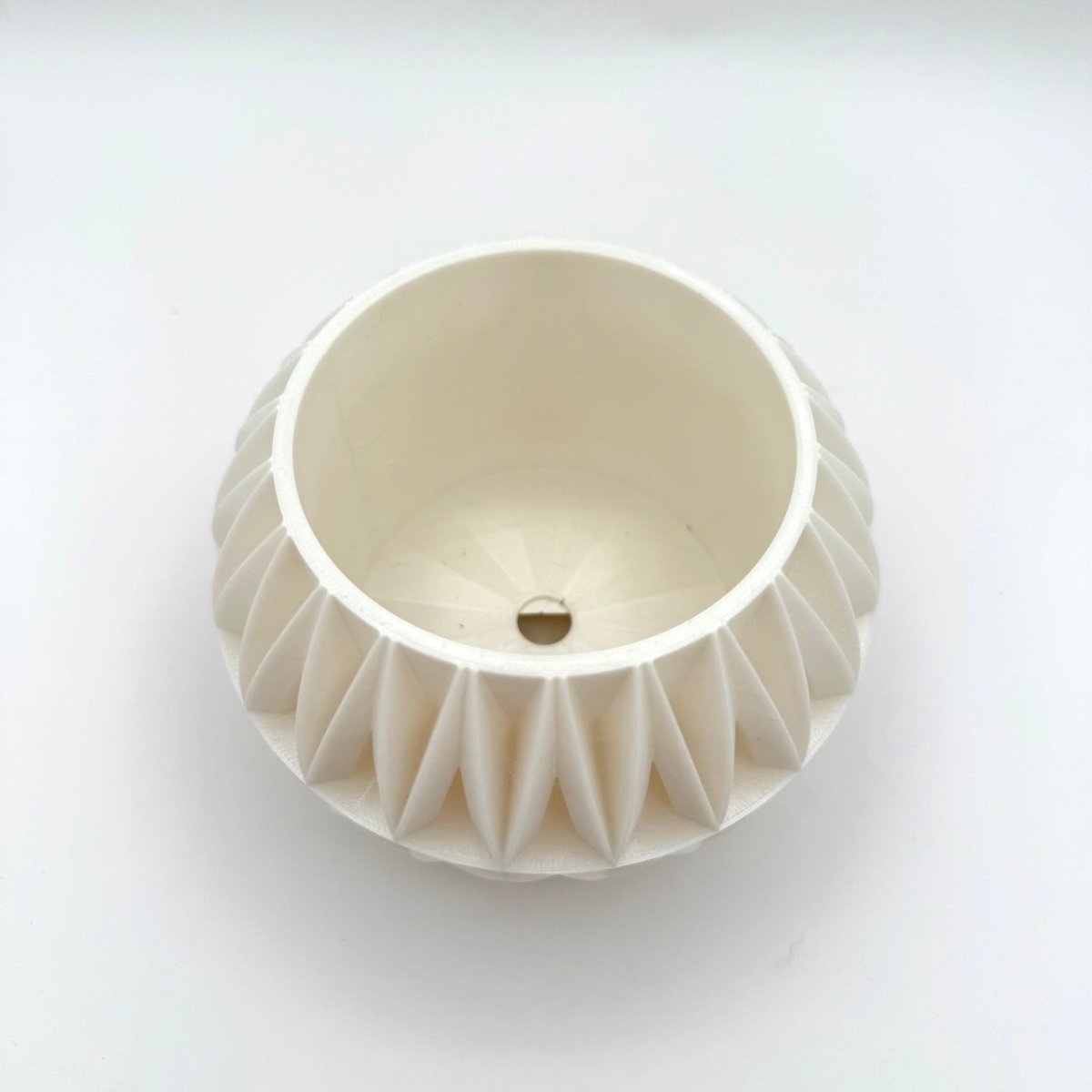 White garden gate indoor planter pot top down view of drainage hole