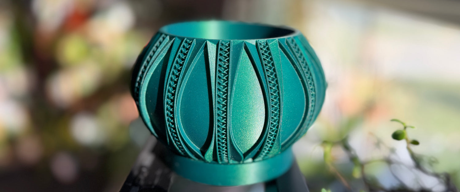 Emerald gold cross stitch 3D printed planter for houseplants on a blurred background